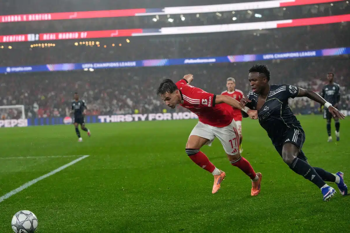 Real Madrid's Vinicius Junior battles for the ball with Benfica's Amar Dedic during a Champions League match, 2026